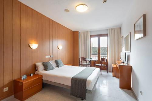 a hotel room with a bed and a table and chairs at Alda Ciudad de Toro in Toro