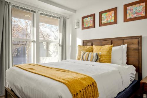 ein Schlafzimmer mit einem großen Bett und einem Fenster in der Unterkunft Chic City Park Home - Rooftop Deck - Skyline Views in Denver