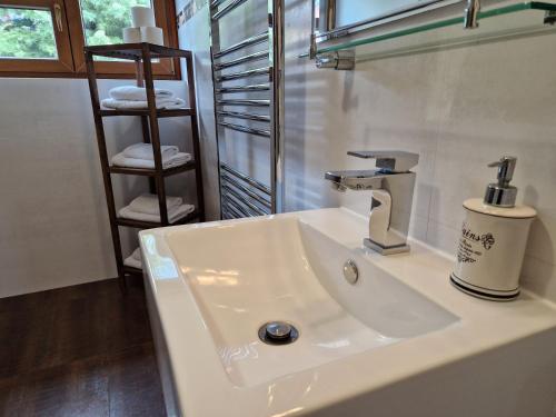a white bathroom sink with a faucet and towels at Chata Marta in Boží Dar