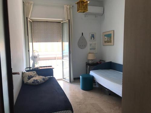 1 dormitorio con 1 cama y ventana con puerta en Frontemare en Crotone