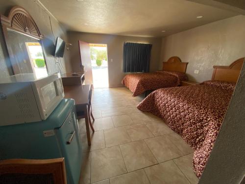 Habitación de hotel con 2 camas y TV de pantalla plana. en Apple Valley Motel en Apple Valley