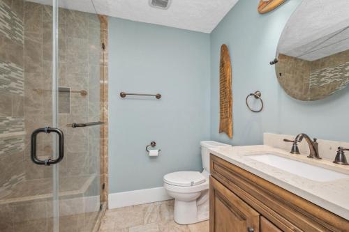 a bathroom with a shower and a toilet and a sink at Fairwinds by Oak Island Accommodations in Caswell Beach