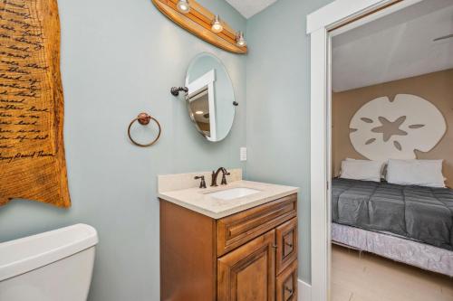 a bathroom with a sink and a mirror at Fairwinds by Oak Island Accommodations in Caswell Beach