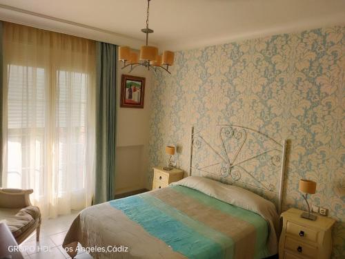 1 dormitorio con 1 cama en una habitación con papel pintado en Casa Pablo Picasso 9, en Jimena de la Frontera