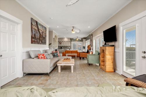a living room with a couch and a tv at Fairwinds by Oak Island Accommodations in Caswell Beach