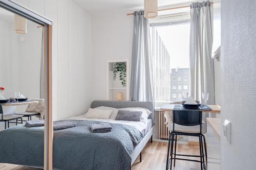 Schlafzimmer mit einem Bett, einem Tisch und einem Fenster in der Unterkunft Nordstay - Lovely Central Studio with self check-in in Helsinki