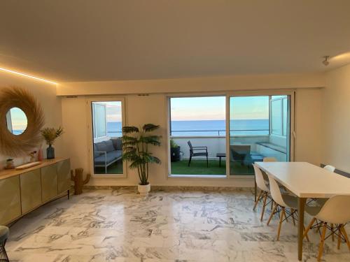 - un salon avec une table et une vue sur l'océan dans l'établissement Magnifique vue mer la Californie, à Nice