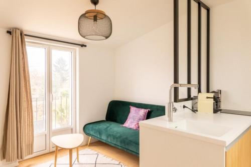ein Wohnzimmer mit einem grünen Sofa und einem Fenster in der Unterkunft Mansion with private pool in Rezé