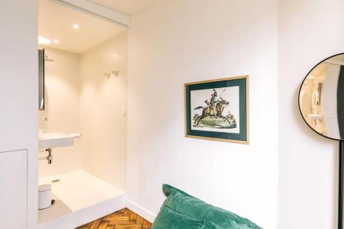 baño con paredes blancas y sofá verde en Bright apartment in the 10Arr. - 4 people, en París