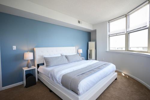 1 dormitorio con 1 cama grande y pared azul en Ballston Getaway King Suite, en Arlington