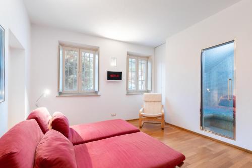 ein Wohnzimmer mit einem roten Sofa und Fenstern in der Unterkunft Casa Gaia in Guarene