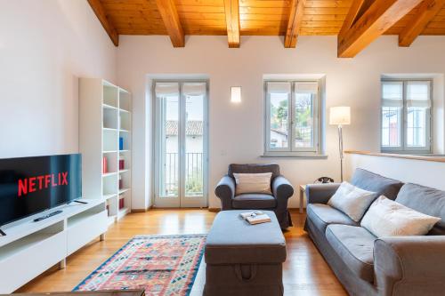 ein Wohnzimmer mit einem Sofa und einem TV in der Unterkunft Casa Gaia in Guarene