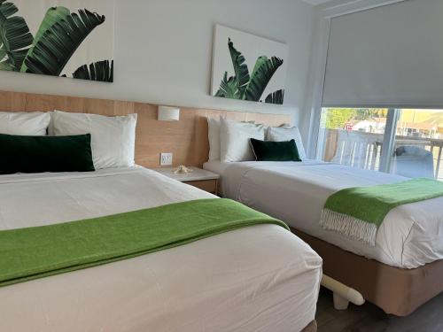 una camera con due letti con lenzuola verdi e una finestra di Gilbert's Resort a Key Largo