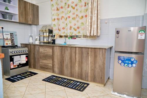 a kitchen with a counter and a refrigerator at Olivet Homes- California plaza in Nanyuki