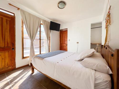 um quarto com uma cama e uma grande janela em Hostal Villa Italo em Copiapó