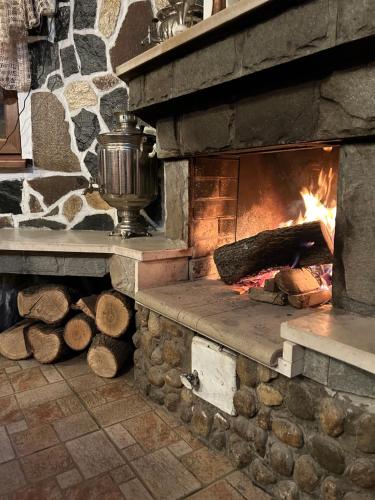 a stone oven with a fire in it at Guest House Rila in Govedartsi