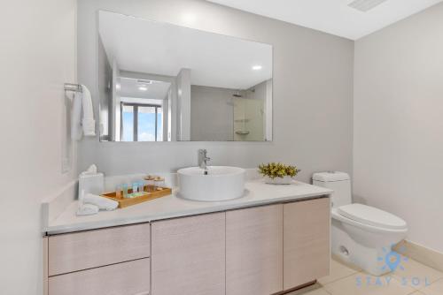 uma casa de banho com um lavatório, um WC e um espelho. em Amazing View - Pool - Gym - 2 Bedrooms em Hallandale Beach