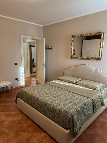 a bedroom with a large bed with a mirror on the wall at Casa Begaj in San Giovanni Valdarno