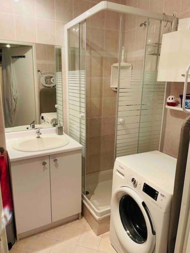 une salle de bain avec une machine à laver et un lavabo dans l'établissement Port Azur Studio cabine 4 P - Pool beach Golfe Juan 5 min Cannes, à Vallauris