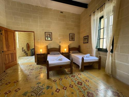 a bedroom with two beds and a window at Tal-Kaptan in Victoria