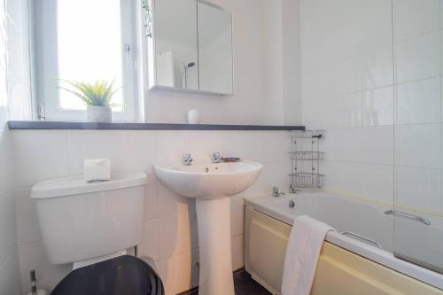 a bathroom with a sink and a toilet and a tub at Pass the Keys Prime Paisley with Parking in Paisley