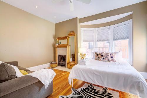 ein Schlafzimmer mit einem Bett, einem Sofa und einem Fenster in der Unterkunft Stunning Historic Home - DT Location! - Sleeps 8 in Denver