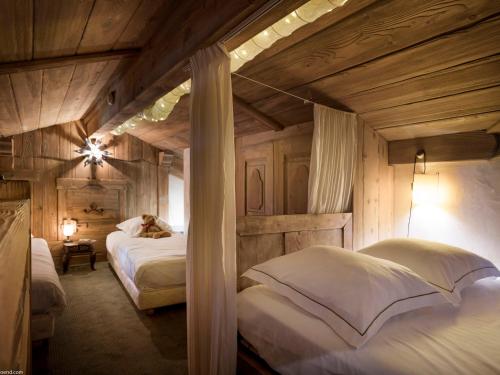 a bedroom with two beds in a room with wooden walls at Appartement de standing à Courchevel 1850 avec cheminée et accès ski aux pieds - FR-1-575-2 in Courchevel
