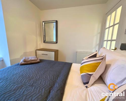 een slaapkamer met een bed en een spiegel bij 1 Bedroom Apartment by Central Serviced Apartments - Close To University of Dundee - Sleeps 2 - Ground Level - Self Check In - Modern and Cosy - Fast WiFi - Heating 24-7 in Dundee