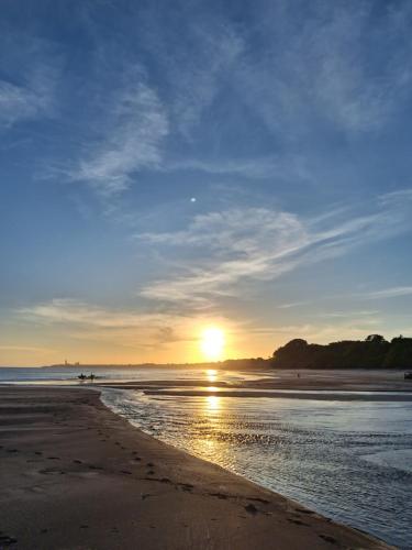 a sunset on a beach with the sun setting at The Blue House Panama in Chame
