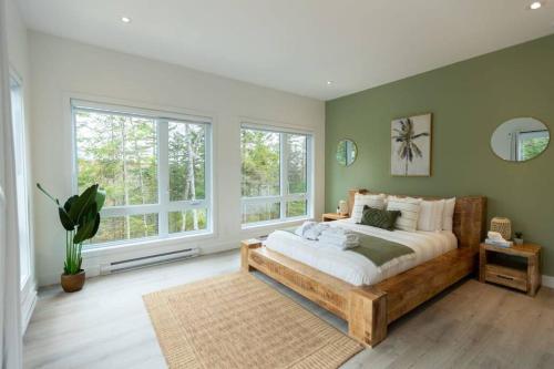 1 dormitorio con 1 cama grande y ventanas en NaturÔzen Private Hot Tub Sauna Lakeside, en Brownsburg
