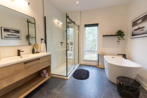 ein Bad mit einer Badewanne, einem Waschbecken und einer Dusche in der Unterkunft NaturÔzen Private Hot Tub Sauna Lakeside in Brownsburg