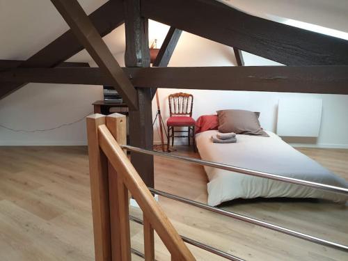 a attic room with a bed and a chair at Charming & practical near Paris in Gentilly
