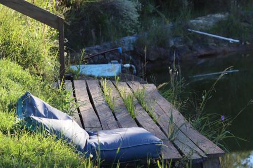 anlatablelatable raft sitting on a wooden bridge over a body of water at Casa Ócio By Canela do Mato in Palomas