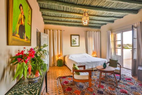 1 dormitorio con 1 cama y 1 mesa en una habitación en Les Jardins De Mogador yoga et SPA, en Essaouira
