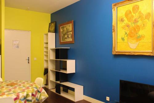 Cette chambre dispose d'un lit et d'une peinture murale. dans l'établissement Colored Appt To Beaugrenelle, à Paris