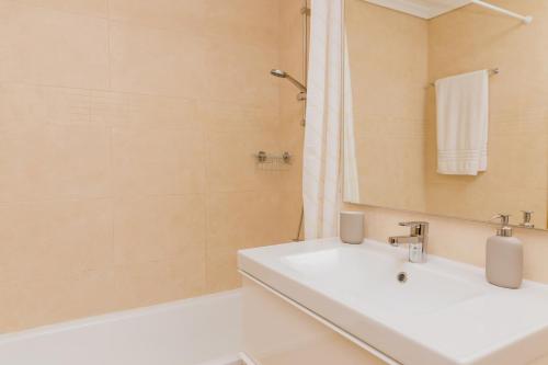 een badkamer met een witte wastafel en een douche bij Veranda Golden Beach II Apartment Javea Arenal in Jávea