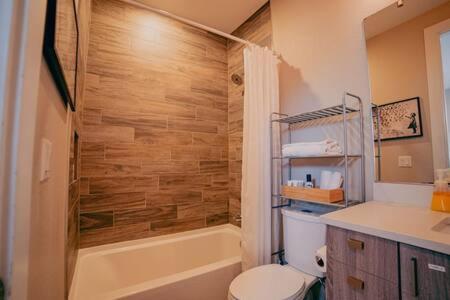 uma casa de banho com um WC, uma banheira e um lavatório. em Denver Urban Retreat - 3BR Rooftop w City Views em Denver