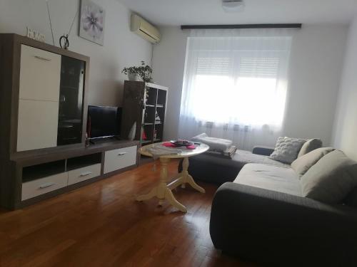 a living room with a couch and a tv and a table at Trnsko in Zagreb