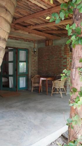 un patio con tavolo, sedie e muro di mattoni di Nongu Home a Trincomalee