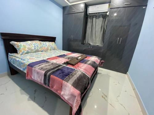 a bed in a room with a black cabinet at Millennia service apartments in Hyderabad