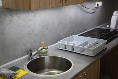 a kitchen counter with a sink and a stove at Kolík Apartmány in Bohumín