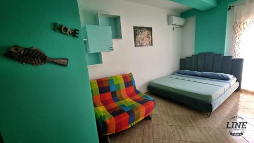 a bedroom with a bed and a colorful chair at Diego Rooms Vlora in Vlorë