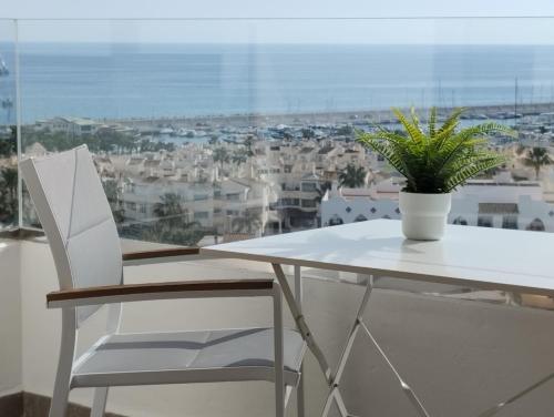 Una mesa blanca y una silla con una planta. en Apartamento privado en Hotel Sol Aloha en Torremolinos