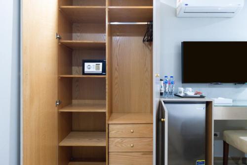 a cupboard with a television and a refrigerator in a room at Mamlouk Pyramids Hotel in Cairo