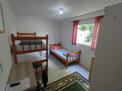 um pequeno quarto com 2 beliches e uma mesa em HOSTEL INN LAGO em Guarapuava