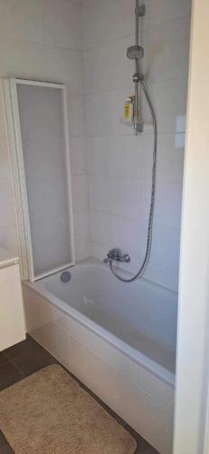 uma banheira com chuveiro na casa de banho em WH65 gezellig vakantiehuis 4pers. em Koksijde