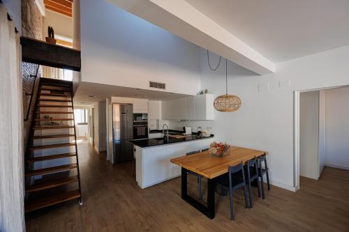 cocina y comedor con mesa de madera en Atico Duplex Playa Area Barcelona con SPA exterior en Montgat