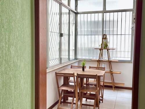 een tafel en stoelen in een kamer met een raam bij Apartamento Inteiro na Praia de Icaraí com Vista in Niterói