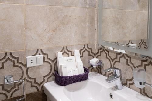 a bathroom with a sink with a basket on it at Mamlouk Pyramids Hotel in Cairo