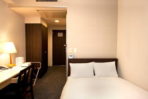 a bed in a hotel room with a desk and a bed sidx sidx at Smile Hotel Asakusa - Vacation STAY 72165v in Tokyo